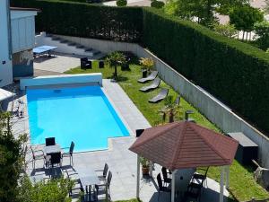 una vista aérea de una piscina con sillas y sombrilla en Apartments Andante, en Rust