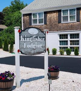 a sign in front of a house with flowers at Kingfisher Lodging in Dennis