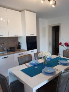 a kitchen and dining room with a white table and chairs at Seaview Apartment Ilovik in Ilovik