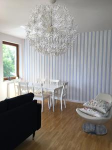 a dining room with a table and a chandelier at Ełk Blue Apartment przy promenadzie in Ełk