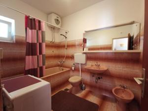 ein Badezimmer mit Waschbecken, Toilette und Spiegel in der Unterkunft House Smajić in Dubrovnik