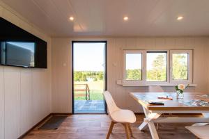 a dining room with a table and a television at Szuflandia in Giżycko