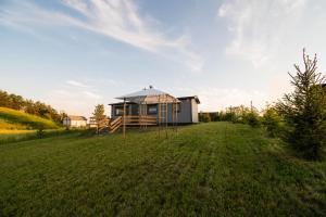 a small house in a field with a grass yard at Szuflandia in Giżycko