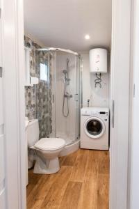 a bathroom with a shower toilet and a washing machine at Szuflandia in Giżycko +23 photos