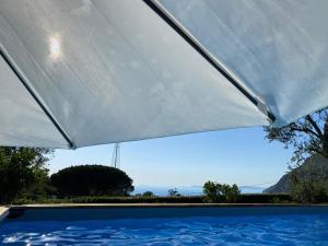 una gran sombrilla blanca sobre una piscina en My Place Home & Garden, en Meta