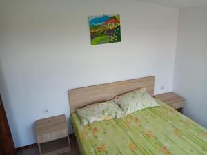 a bed with a green comforter in a bedroom at Varna Holiday in Varna City