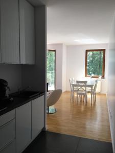 a kitchen and dining room with a table and chairs at Ełk Blue Apartment przy promenadzie in Ełk