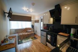 a kitchen and a living room with a couch in it at Fennec Apartments in Cherry Hinton