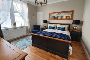a bedroom with a large bed and a mirror at Smart & Stylish Holiday Apartment in the city centre in Inverness