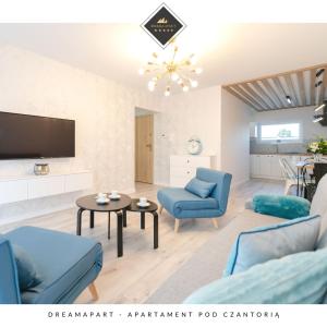 a living room with blue chairs and a tv at Apartament Pod Czantorią z tarasem - Dream Apart in Ustroń