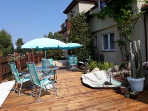 a patio with a table and chairs and an umbrella at Pokoje gościnne MOTYLEK in Dźwirzyno