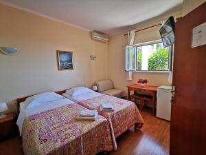 ein Schlafzimmer mit einem Bett, einem Schreibtisch und einem Fenster in der Unterkunft House Smajić in Dubrovnik