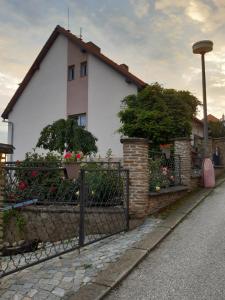 ein Haus mit einem Zaun und Blumen davor in der Unterkunft Apartment Adéla in Hluboká nad Vltavou