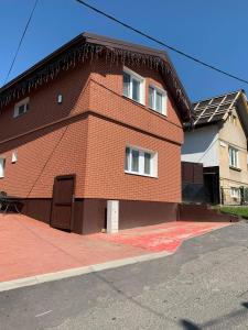 a red brick building with a brown door on a street at Ubytovanie MI - TATRY in Kravany