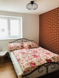 sypialnia z łóżkiem z ceglaną ścianą w obiekcie Ubytovanie MI - TATRY w mieście Kravany