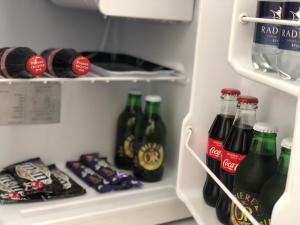 a refrigerator filled with lots of bottles of soda at Southsea Studios - Luxury Seaside Apartments in Portsmouth