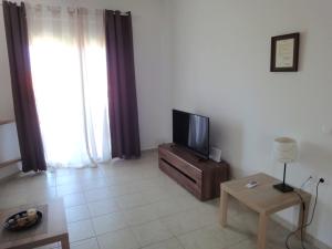 a living room with a tv and a table at Polychrono Nikos Apartment in Polychrono