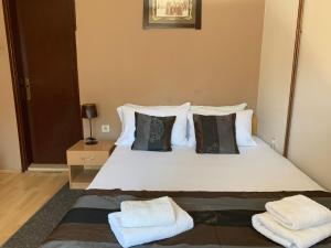 1 dormitorio con 1 cama con sábanas y almohadas blancas en Guest Accommodation Zone en Niška Banja