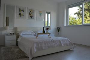 a white bedroom with a bed with a table on it at Apartment Seven in Split