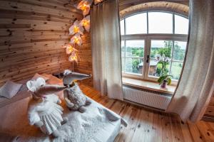 dwa wypchane zwierzęta siedzące na łóżku w pokoju z oknem w obiekcie HANDMADE LATGOLA - vairāk kā vienkārši "naktsmītne" w mieście Līvāni