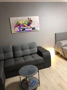 a living room with a couch and a painting of a dog at НОВАЯ КРАСИВАЯ квартира. in Cherkasy