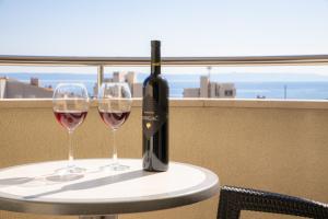 una bottiglia di vino seduta su un tavolo con due bicchieri di Steko Accomodations a Makarska