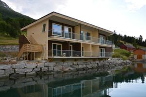 una casa sentada sobre un cuerpo de agua en Nesset Fjordcamping en Olden