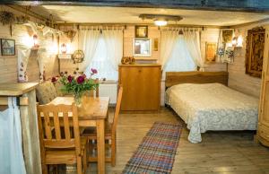 1 dormitorio con cama, mesa y sidra de mesa en Usadba Belovezhskoye Pomestye, en Kamenyuky