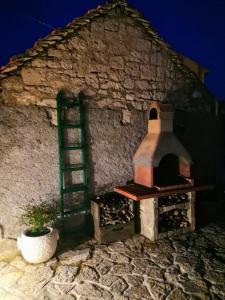 a brick oven with a ladder next to a wall at Holiday Home Little Heaven in Slatine