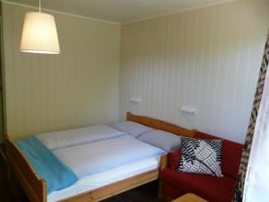 a small bedroom with a bed and a chair at Kvamsdal Pensjonat 3 in Eidfjord