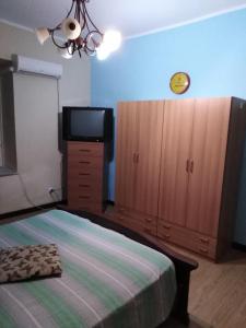 a bedroom with a bed and a dresser and a tv at Casa Vacanze paradiso in Lamezia Terme