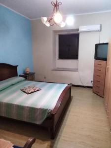 1 dormitorio con 1 cama y TV de pantalla plana en Casa Vacanze paradiso en Lamezia Terme