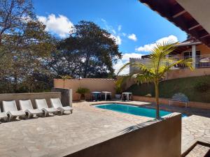 un patio con sillas y una piscina en Chácara Recanto Paraíso, en Serra Negra