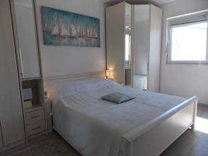 een witte slaapkamer met een bed en een raam bij Warm Terrace Apartments in Zadar