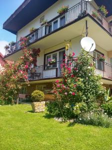 un bâtiment avec des fleurs devant lui dans l'établissement U STASI kwatery, à Piwniczna-Zdrój