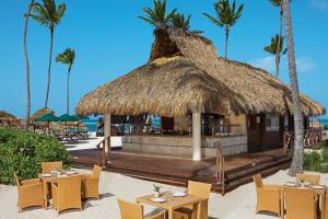 プンタ・カナにあるSecrets Royal Beach Punta Cana - Adults Only - All Inclusiveのヤシの木が茂るビーチ沿いのレストラン