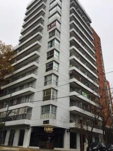 un gran edificio blanco con un cartel. en Lo de Mario al rio en Buenos Aires