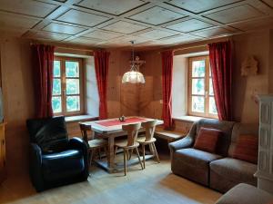 - un salon avec une table, des chaises et un canapé dans l'établissement Haus Thoma, à Stelvio