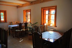 a dining room with tables and chairs and windows at Sudecka Chata in Bystrzyca Kłodzka