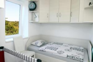 a bed in a small room with a window at Pure nature coastal apartment VLASTA in Ankaran