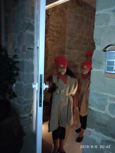 dos chicas con turbantes rojos parados en una puerta en La Casa dei Panorami di Colobraro, en Colobraro