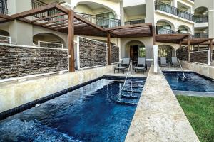 uma piscina interior com cadeiras numa casa em Secrets Royal Beach Punta Cana - Adults Only - All Inclusive em Punta Cana