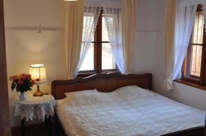 een slaapkamer met een bed en een tafel met een vaas met bloemen bij Villa Nostalgia in Szklarska Poręba
