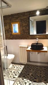 uma casa de banho com um lavatório, um WC e um espelho. em El Solei de Rupit em Rupit