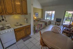 サウス・パドレ・アイランドにあるSandcastle 201B Condominium Condoのキッチンとリビングルーム（テーブルとベッド付き）