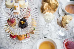 a table with cakes and desserts and a cup of coffee at Baccarat Hotel and Residences New York in New York