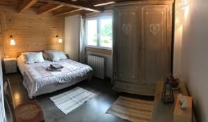 een slaapkamer met een bed en een groot raam bij Chez Julie in Thollon