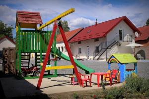 um parque infantil com equipamento colorido em frente a uma casa em Yosefsfeld em Kutjevo