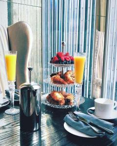 a table with a tray of pastries and orange juice at Baccarat Hotel and Residences New York in New York