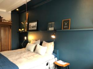 1 dormitorio con 1 cama con pared azul en Elfstedenstate Friesland, en Easterein